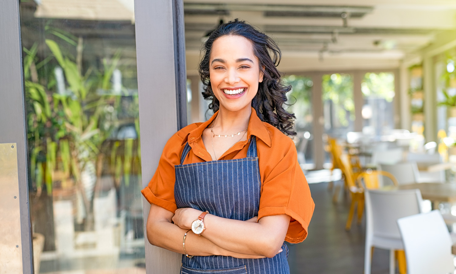 Woman with apron standing in front of business