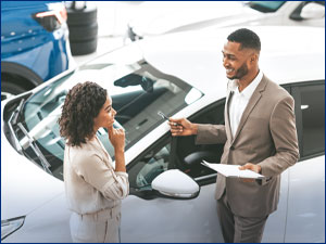 Man selling car to woman