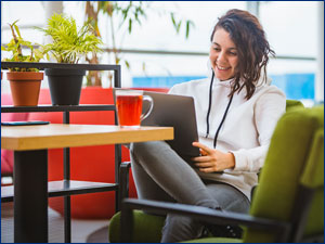woman sitting in chair looking at laptop