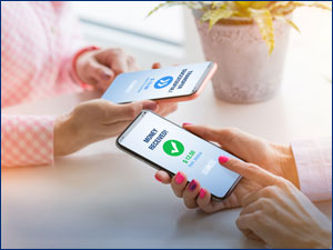 person holding mobile phone looking at a money transfer screen