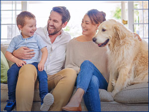 man woman child and dog sitting on the couch