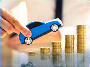 person holding toy car climbing up coins on an incline