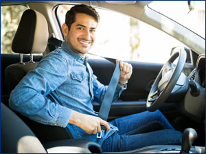 man sitting in the drivers side buckling his seatbelt