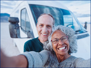 man and woman taking a selfie in front of RV