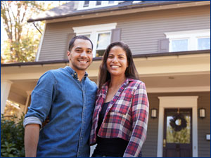 Man and woman standing in front of house