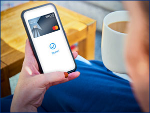 Person holding phone which shows the RBFCU Mastercard.