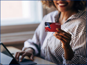 Woman holding an RBFCU debit card.