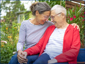 Woman hugging an elderly woman. 