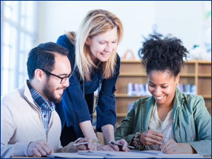 three people working together looking at documents on a table