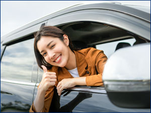 person holding a thumbs up outside of car window