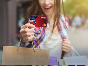 woman holding shopping bags and showing the RBFCU debit card