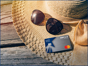 Straw beach hat and sunglasses with RBFCU World Cash Back Mastercard credit card