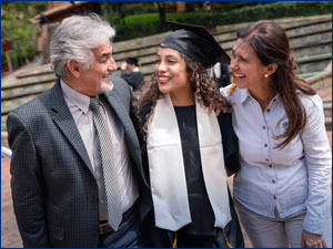 Graduate hugging her parents.