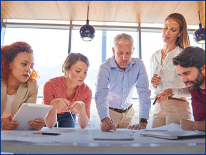 Group of people looking at documents on a table.
