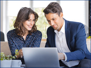 Two people looking at a computer.