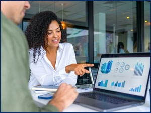 Women pointing at charts on a laptop
