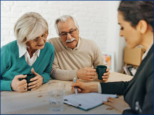 man and woman sitting a person reviewing documents on a clipboard