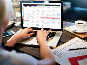 Woman looking at a calendar on her computer.