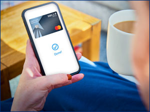 Person holding a phone with the RBFCU Mastercard on it