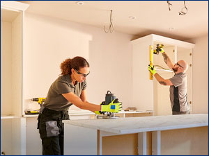 Two people working on a kitchen remodel.