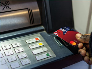 Person using RBFCU debit card at an ATM.
