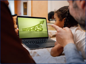 Family looking at laptop that says savings on it.