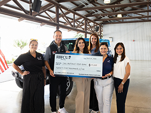RBFCU and Food Bank reps holding check