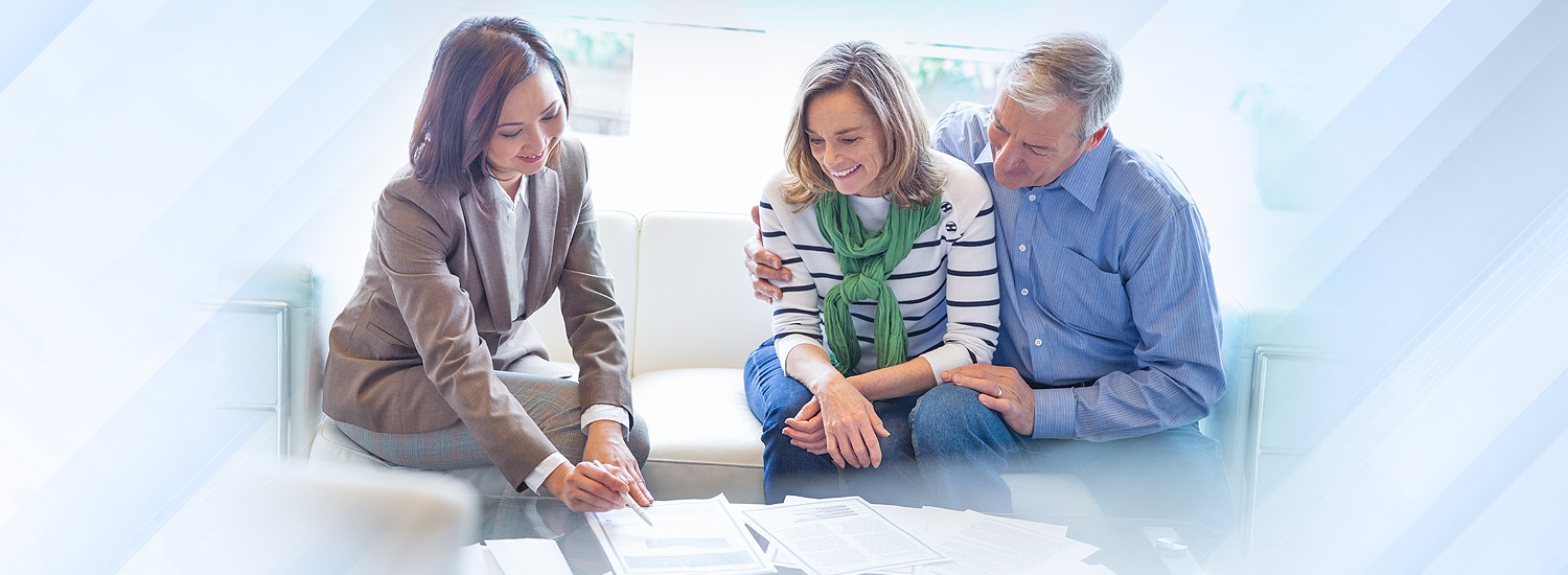 Financial advisor reviews paperwork with woman and man