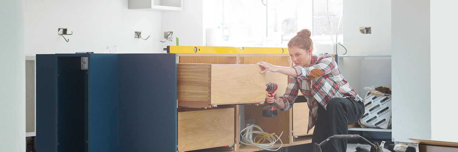 Home-Improvement-Loans-Hero Woman working on cabinets inside a home