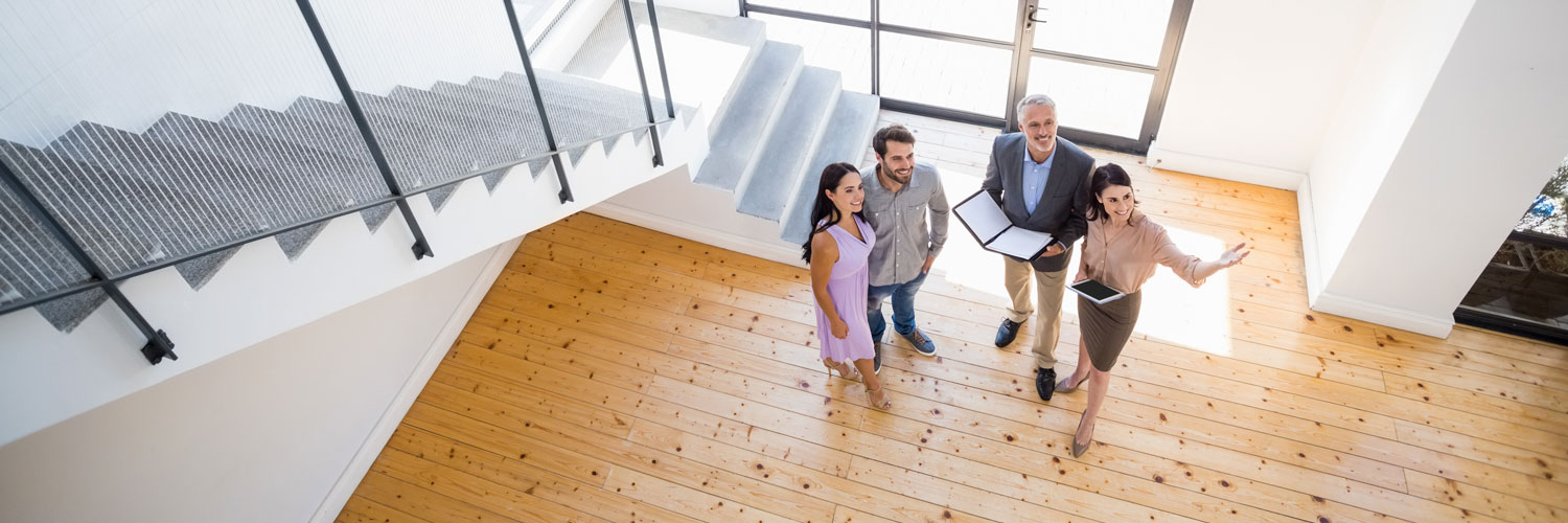 Home-Loans-and-Realty-Hero Realtors showing a house to a couple