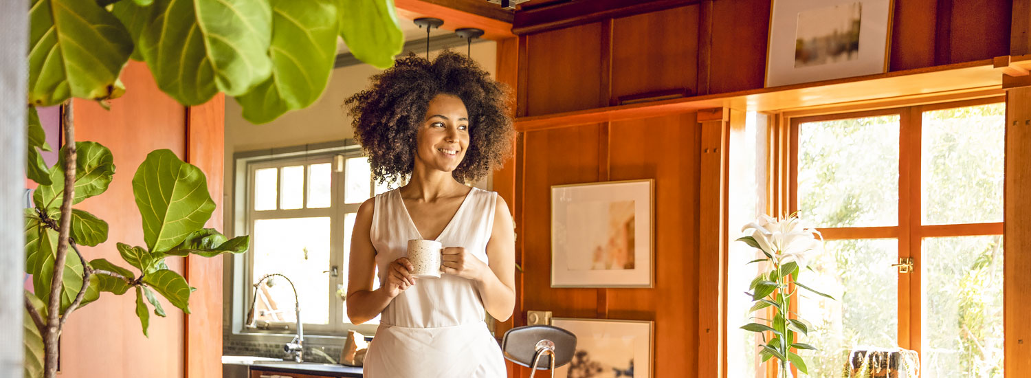INS-AGNCY-Half-Hero-Personal-FIN Woman holding coffee cup and standing in her home