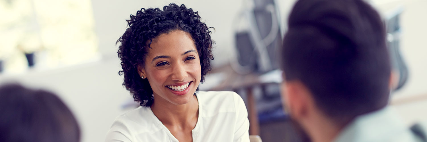 Investments-Overview-Hero-Image Woman smiling at person sitting across from her
