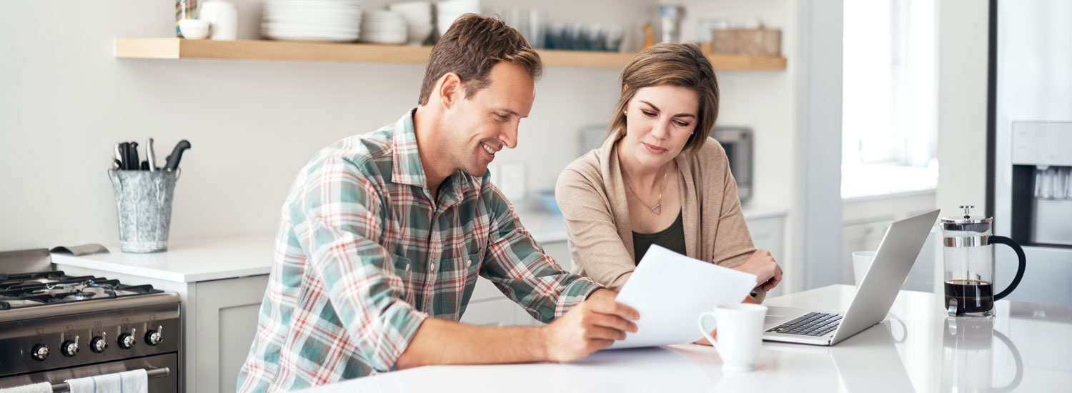 Money-Market-Hero-ImageFinal A man and woman looking at a paper and laptop