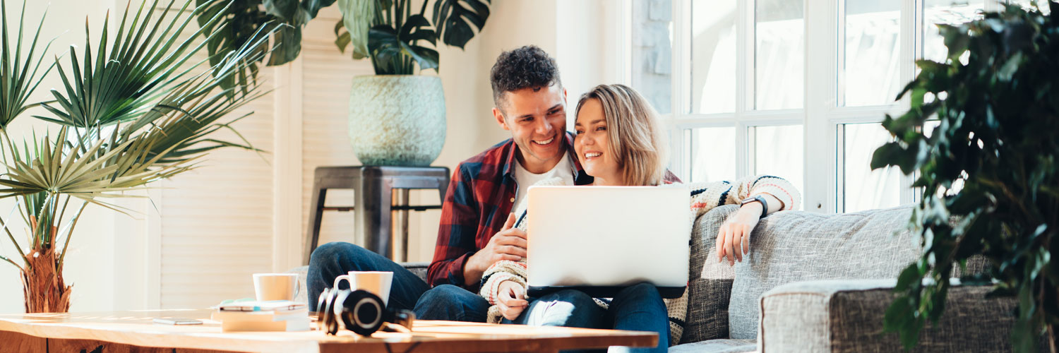 Mortgage-Refinancing-Hero A couple sitting on their couch looking at a laptop