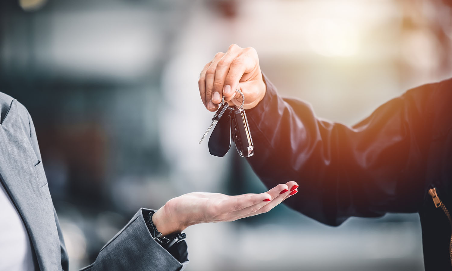 hand giving a car key for vehicle