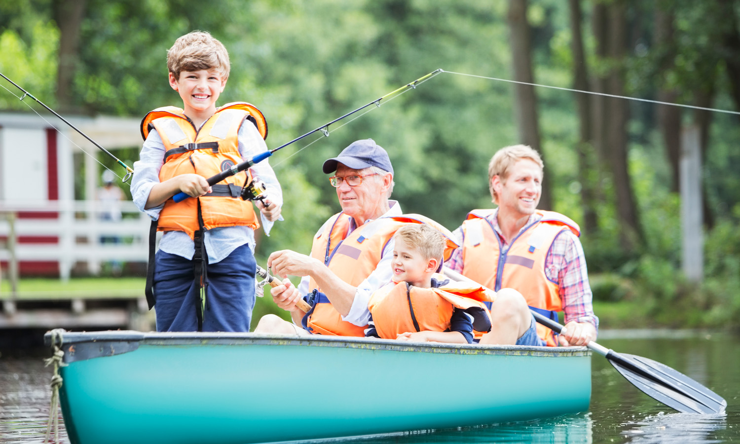 Two men and two children fishing on a boat