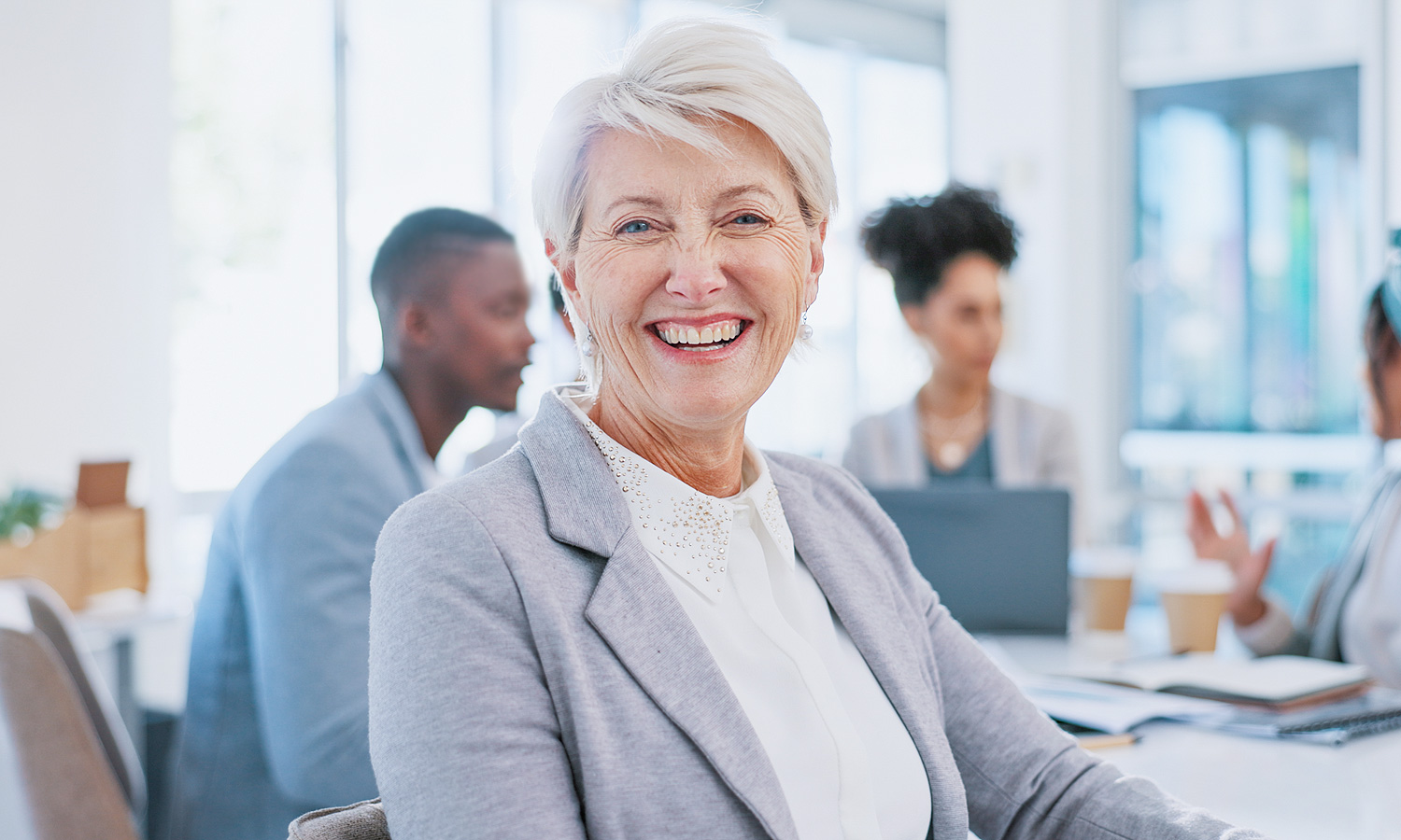 woman smiling while sitting at a table with a group of people