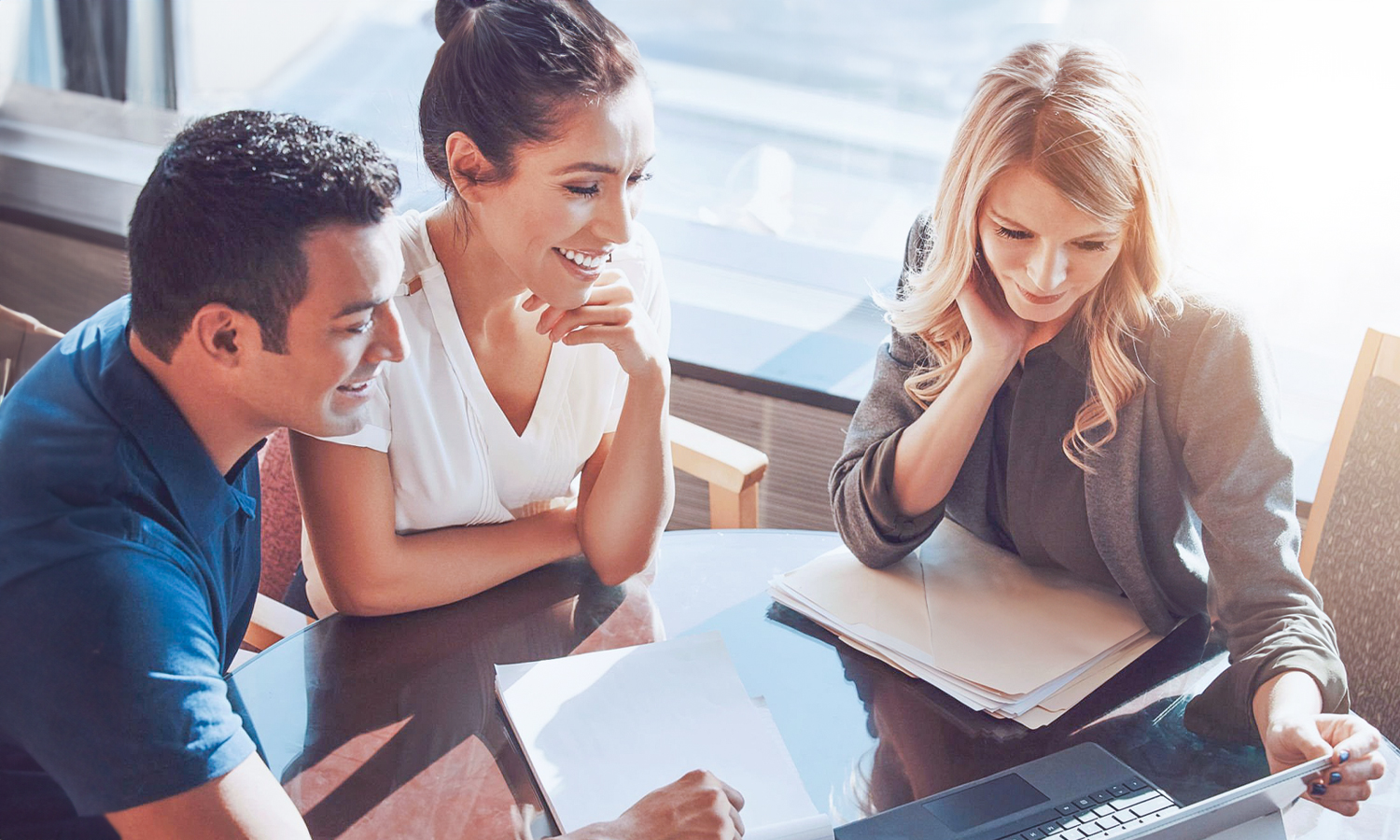 man and woman sitting at a table with an advisor looking at paperwork