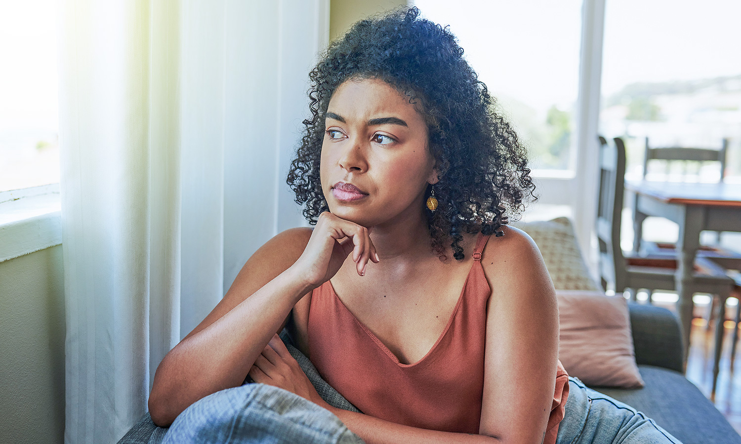 woman sitting down and staring out the window