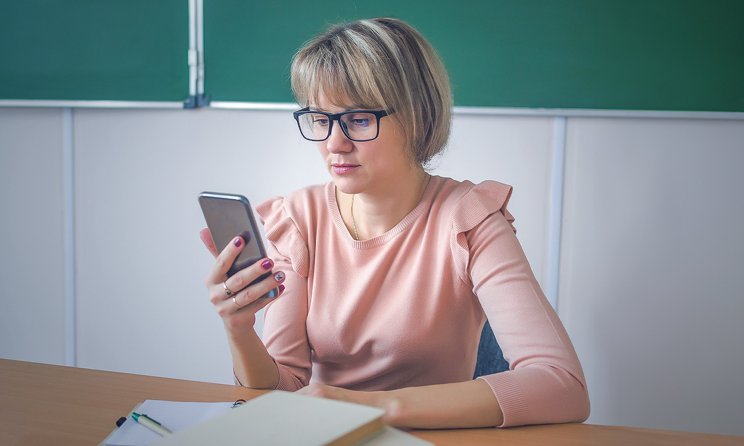 woman looking at mobile phone she's holding in her hand