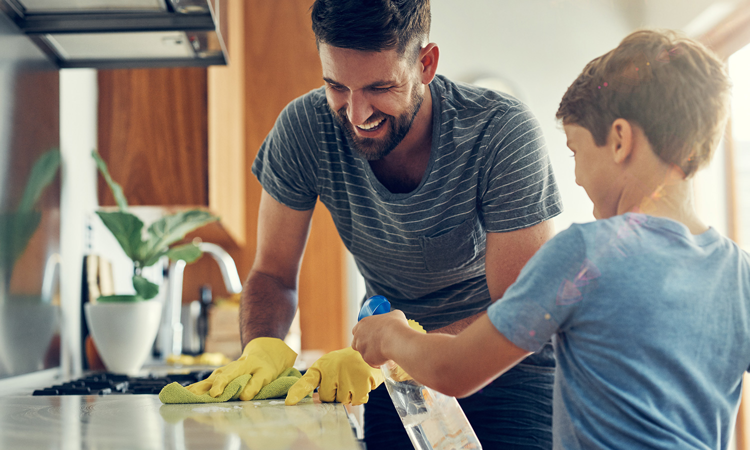 man and boy cleaning kitchen counter