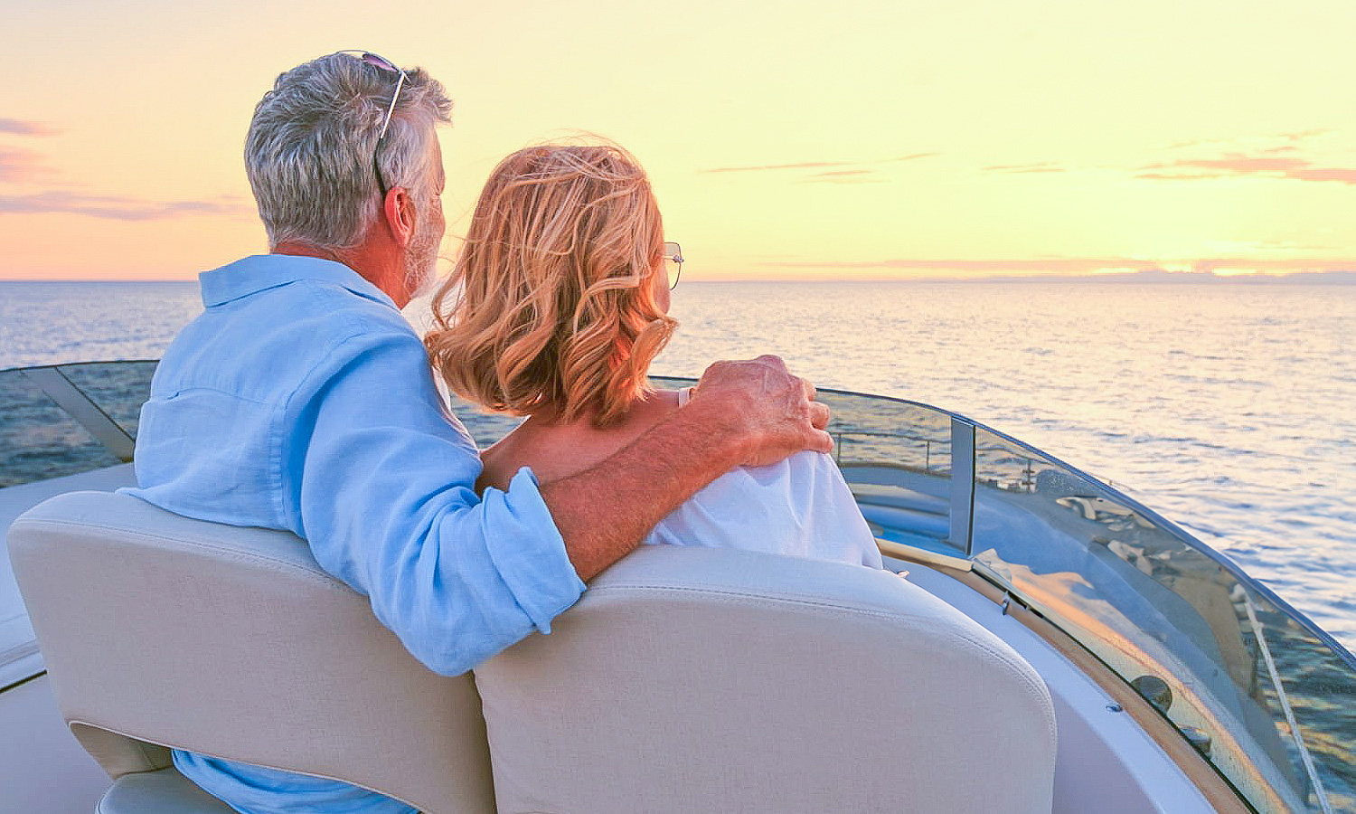 Couple sitting on a boat looking at the sunset.