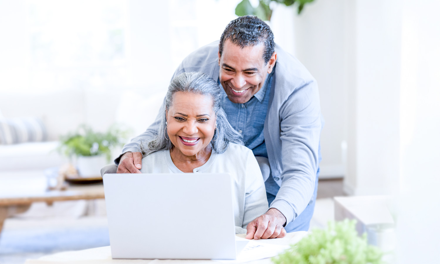 Man working with older woman using computer
