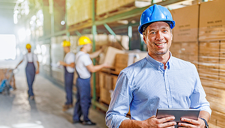 man holding tablet wearing a construction hat