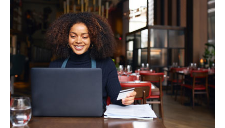 Woman working on a laptop computer at a restaurant