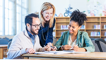 three people looking at paperwork on the table